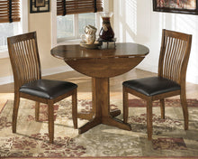 Load image into Gallery viewer, Stuman - Medium Brown - 5 Pc. - Round Drop Leaf Table, 4 Upholstered Side Chairs
